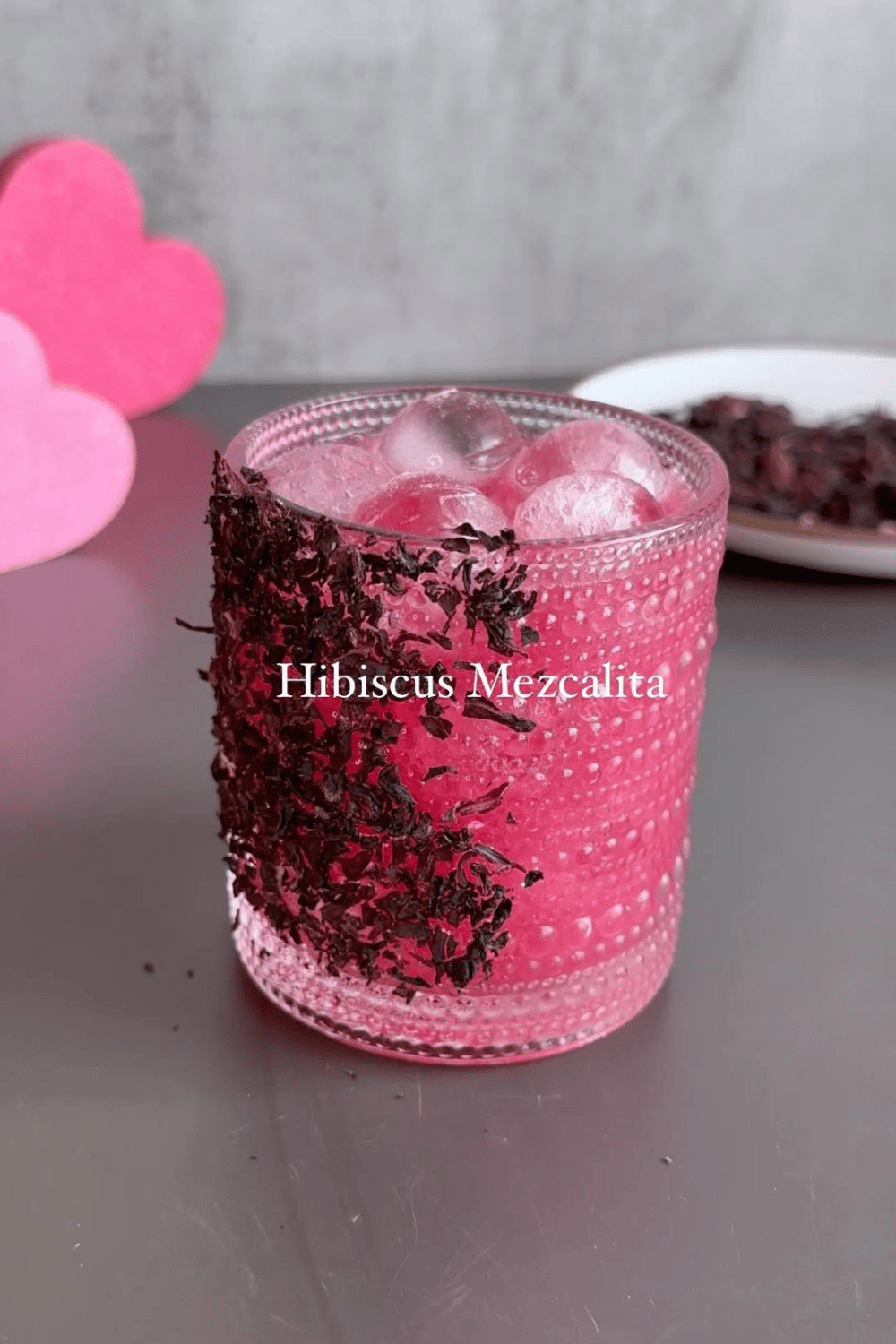 Hibiscus mezcalita cocktail with ice in a pink glass
