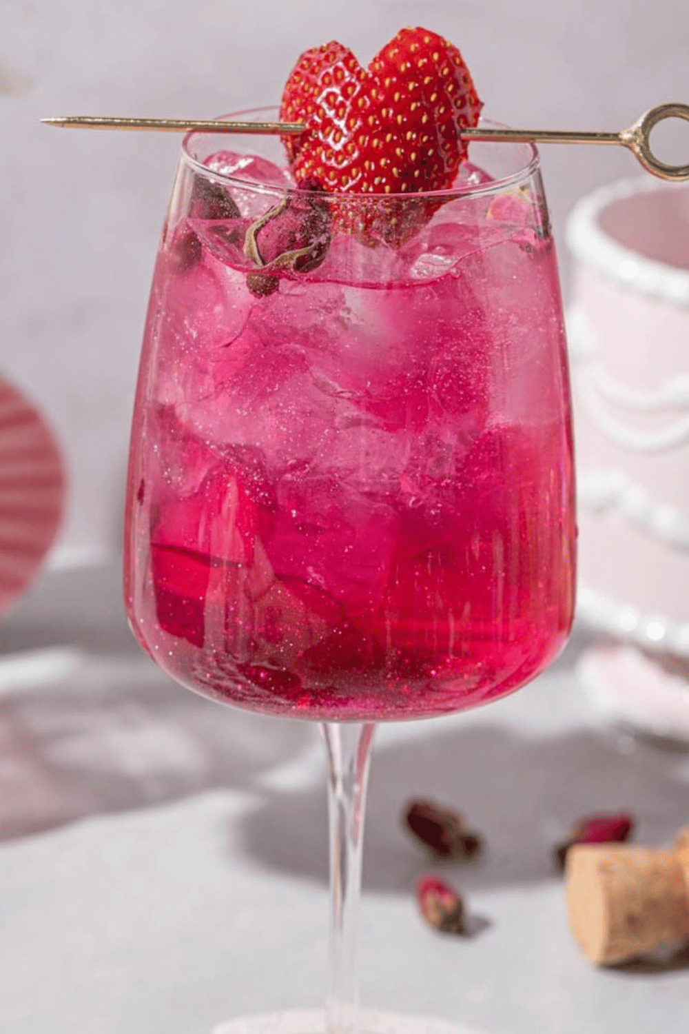 Pink Hugo spritz cocktail with strawberries in a wine glass