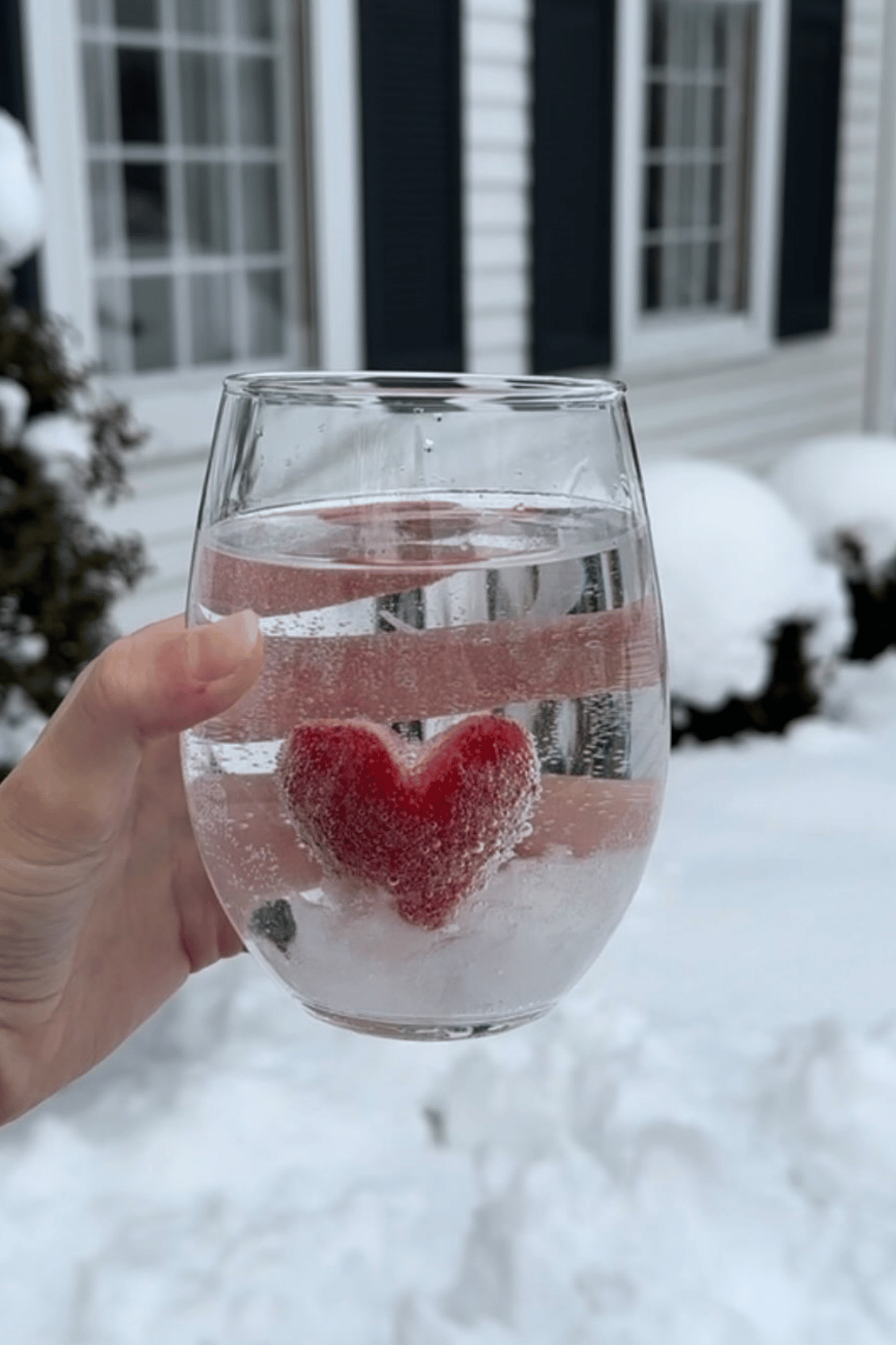 Sparkling water with frozen strawberry heart ice cube