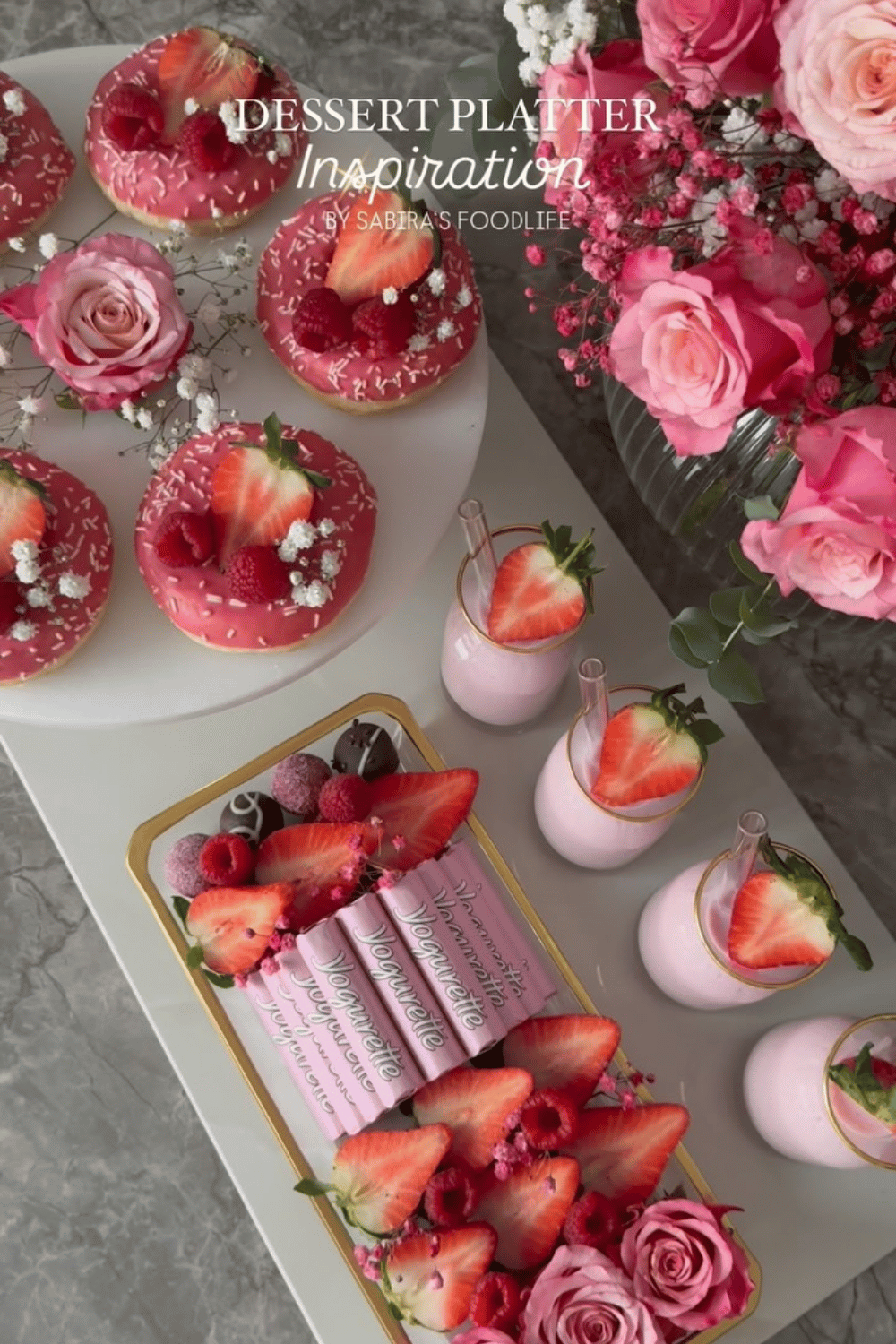 Pink dessert platter with donuts, strawberries, and sweet treats