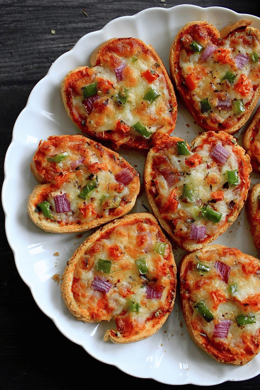 Heart-shaped pizza toasts with cheese and vegetables