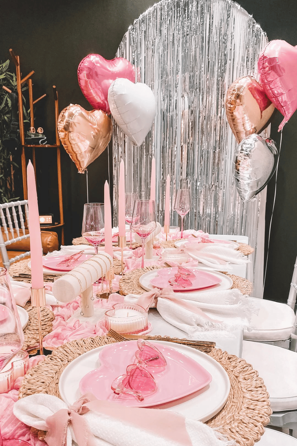Romantic galentine’s tablescape with balloon backdrop and pink place settings