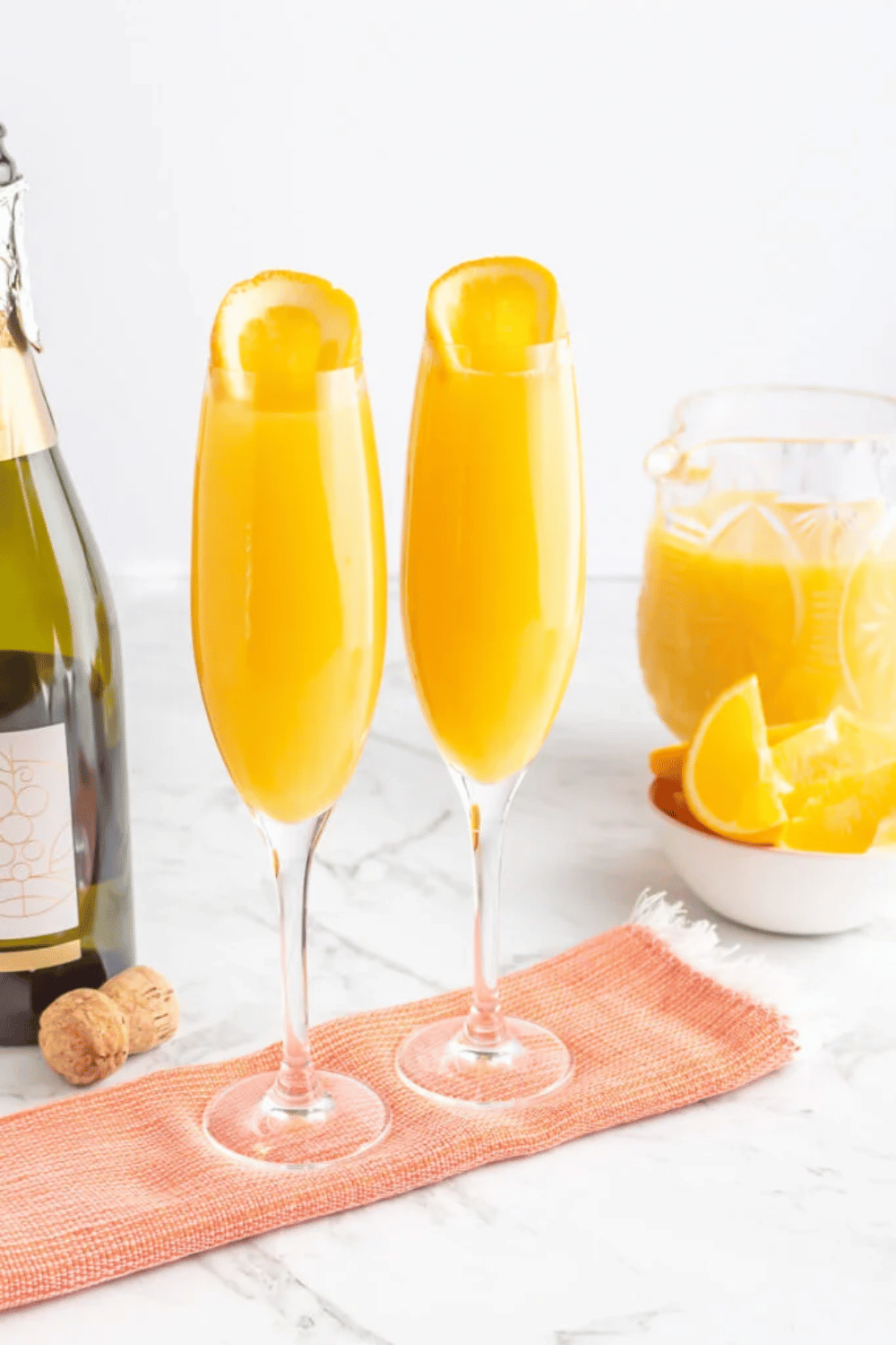 Mimosas served in champagne flutes for galentine’s day brunch