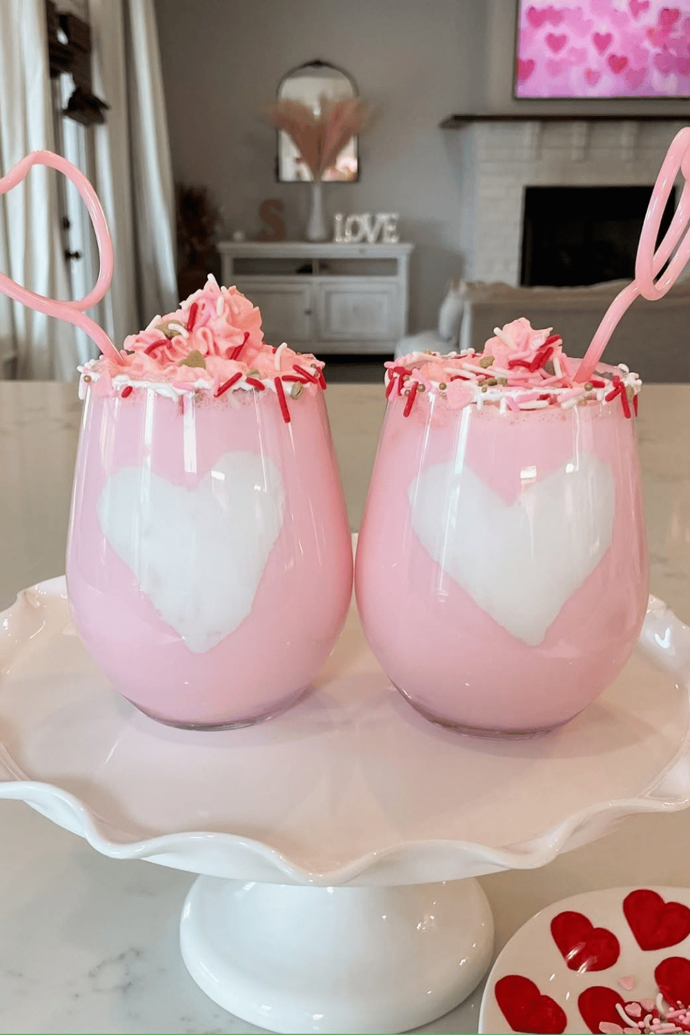 Pink galentine’s day drinks with heart-shaped ice and whipped topping