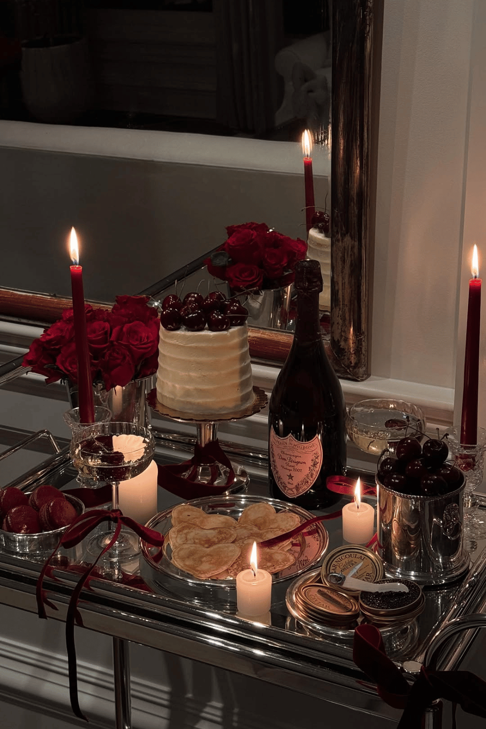 Romantic galentine’s dessert and wine table with candles and heart details