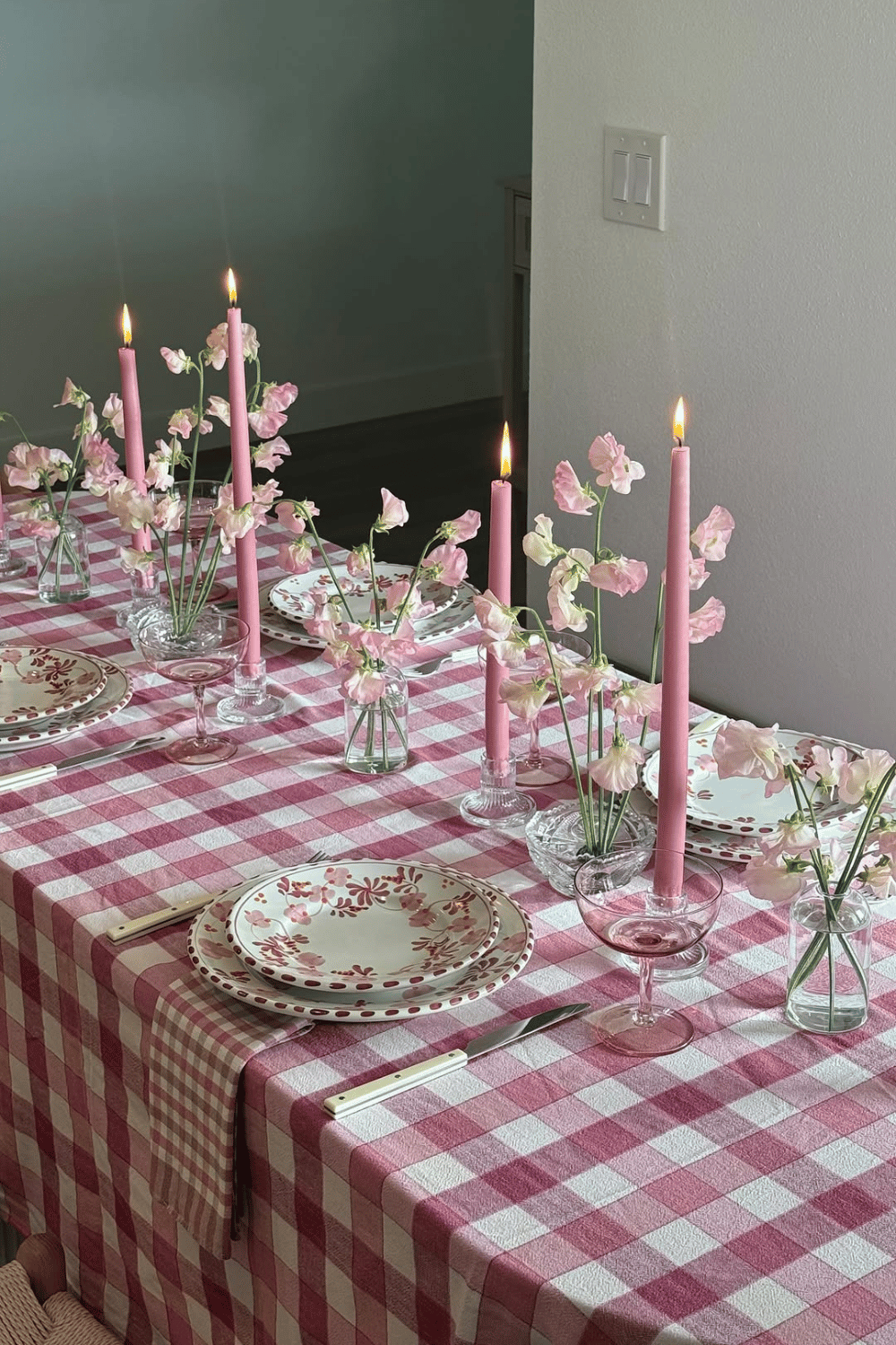 Cozy galentine’s dinner table with pink gingham tablecloth and soft floral decor