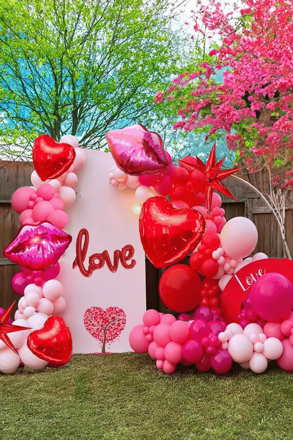 Outdoor galentine’s photoshoot setup with balloon arch and heart decor