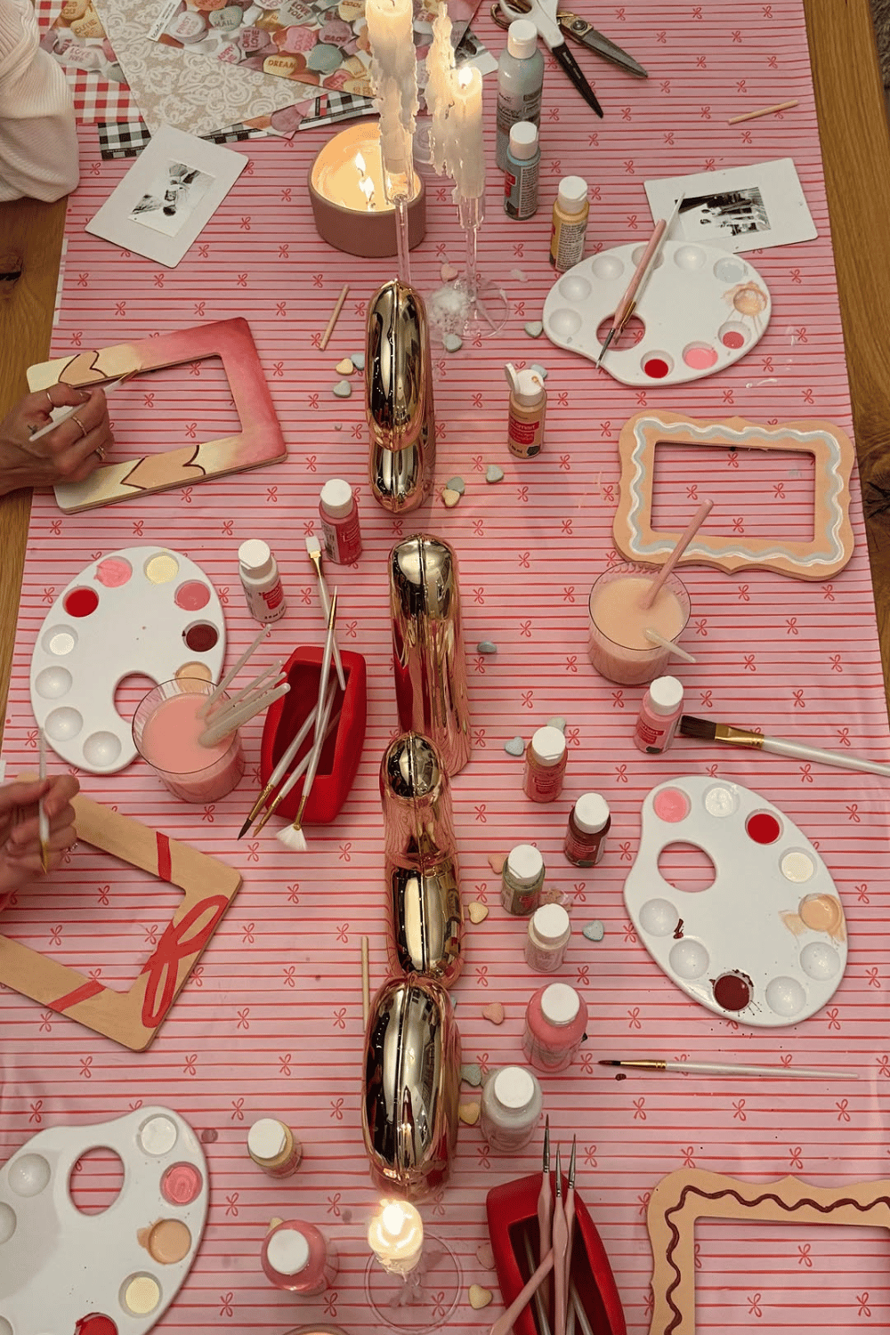 Galentine’s craft table with painting supplies and pink decor
