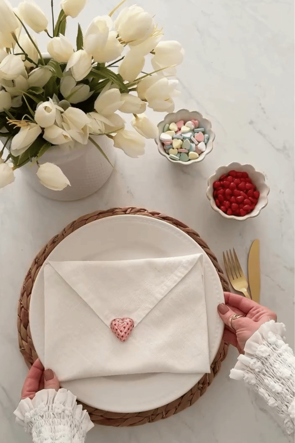 Galentine’s tablescape with white plates, envelope-style napkin fold, and heart detail