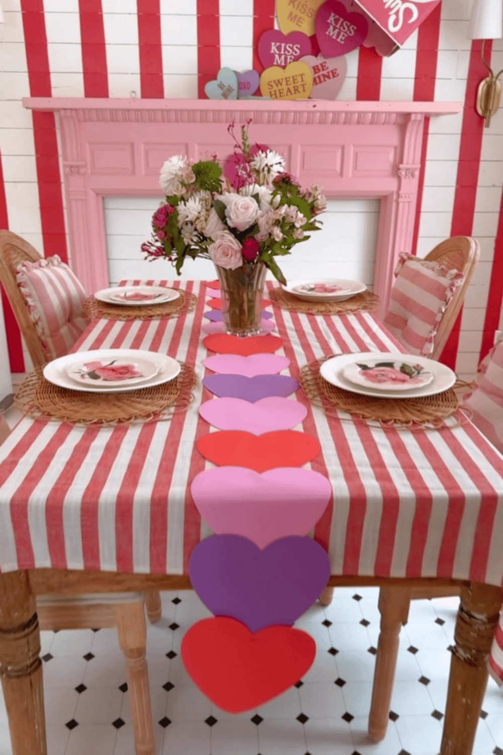Galentine’s table with heart-shaped paper runner, striped tablecloth, and floral centerpiece