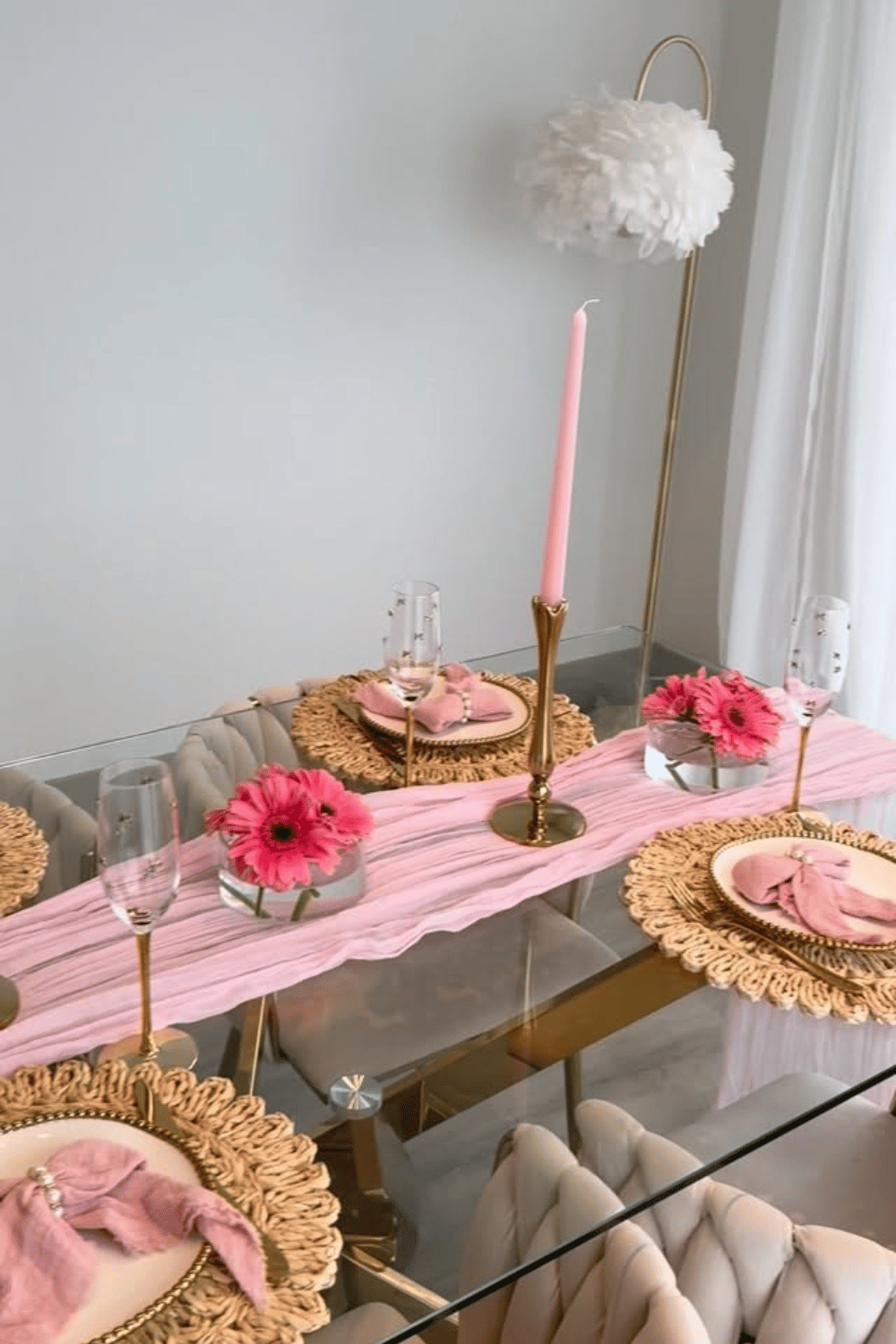 Galentine’s table setting with pink runner, floral centerpieces, and woven placemats
