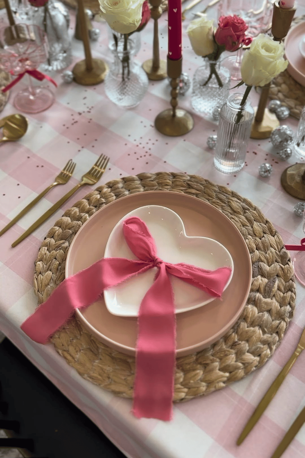 Heart-shaped plate place setting with pink ribbon and romantic table decor