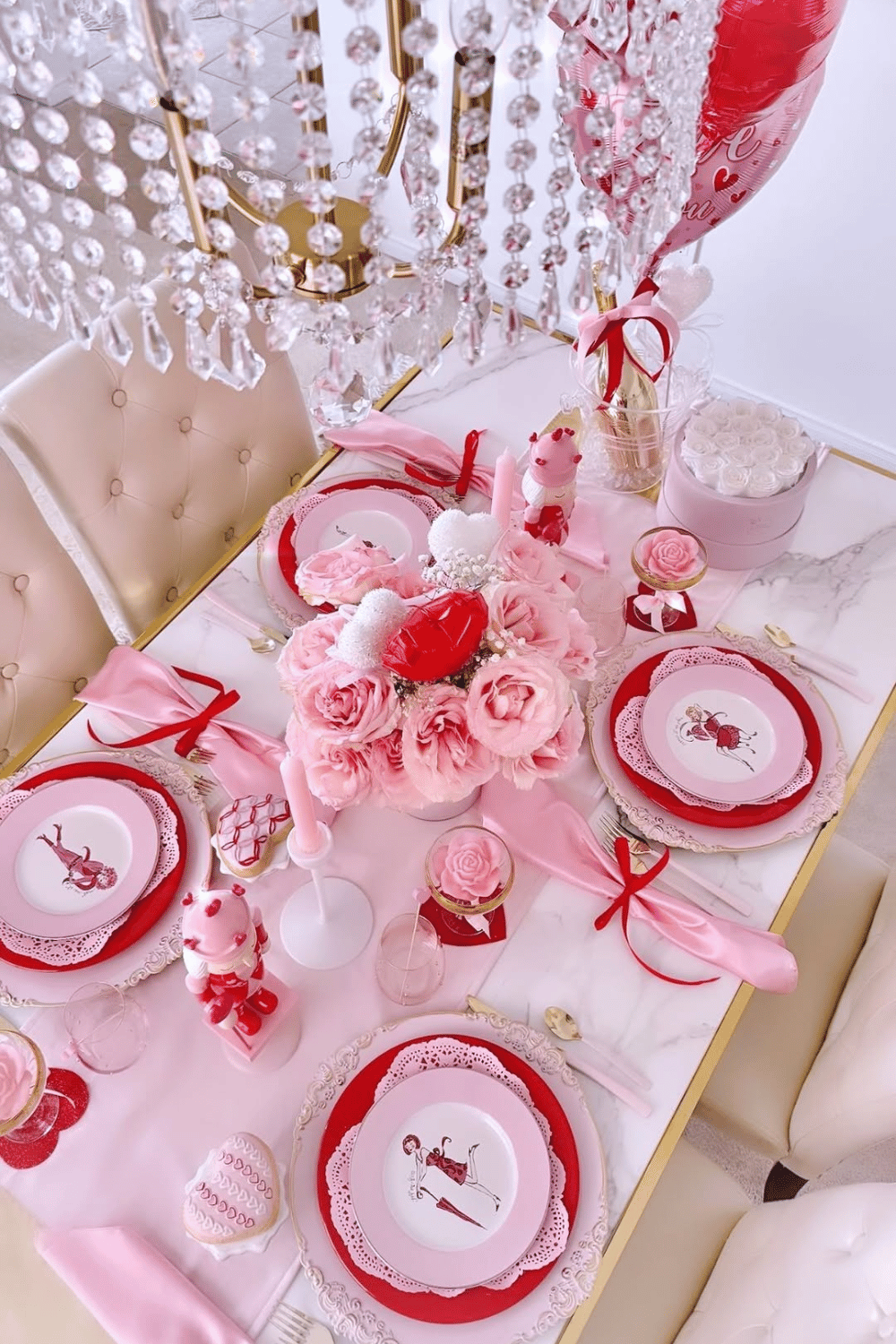 Pink Galentine’s tablescape with floral centerpiece, heart accents, and decorative plates