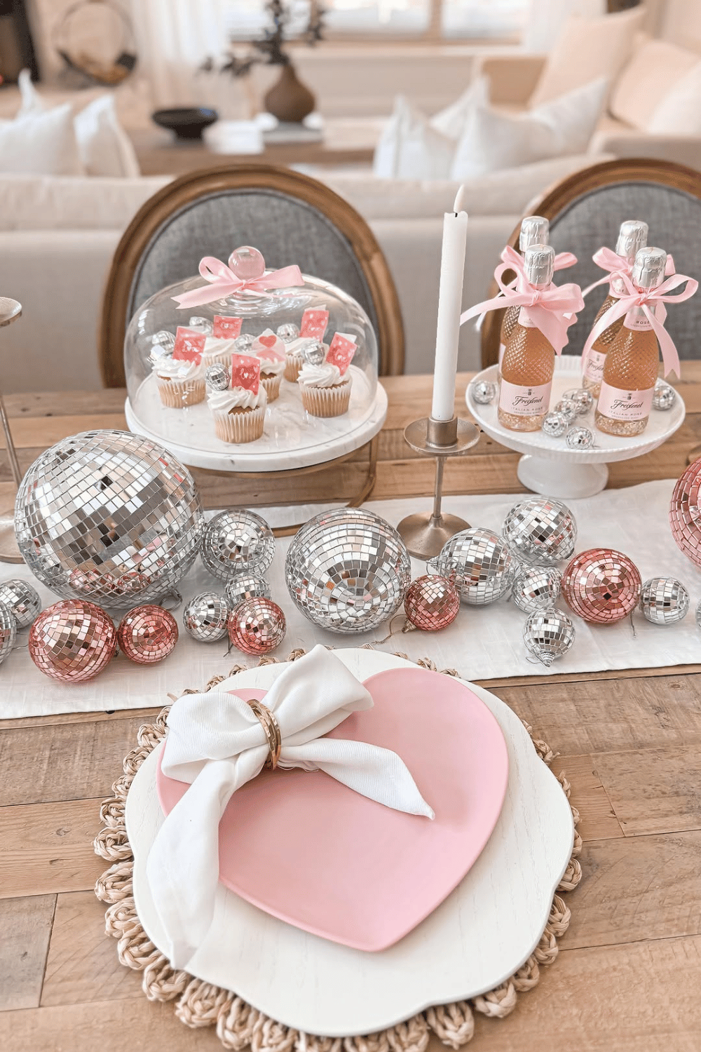 Galentine’s table decor with disco balls, cupcakes, pink accents, and heart plates