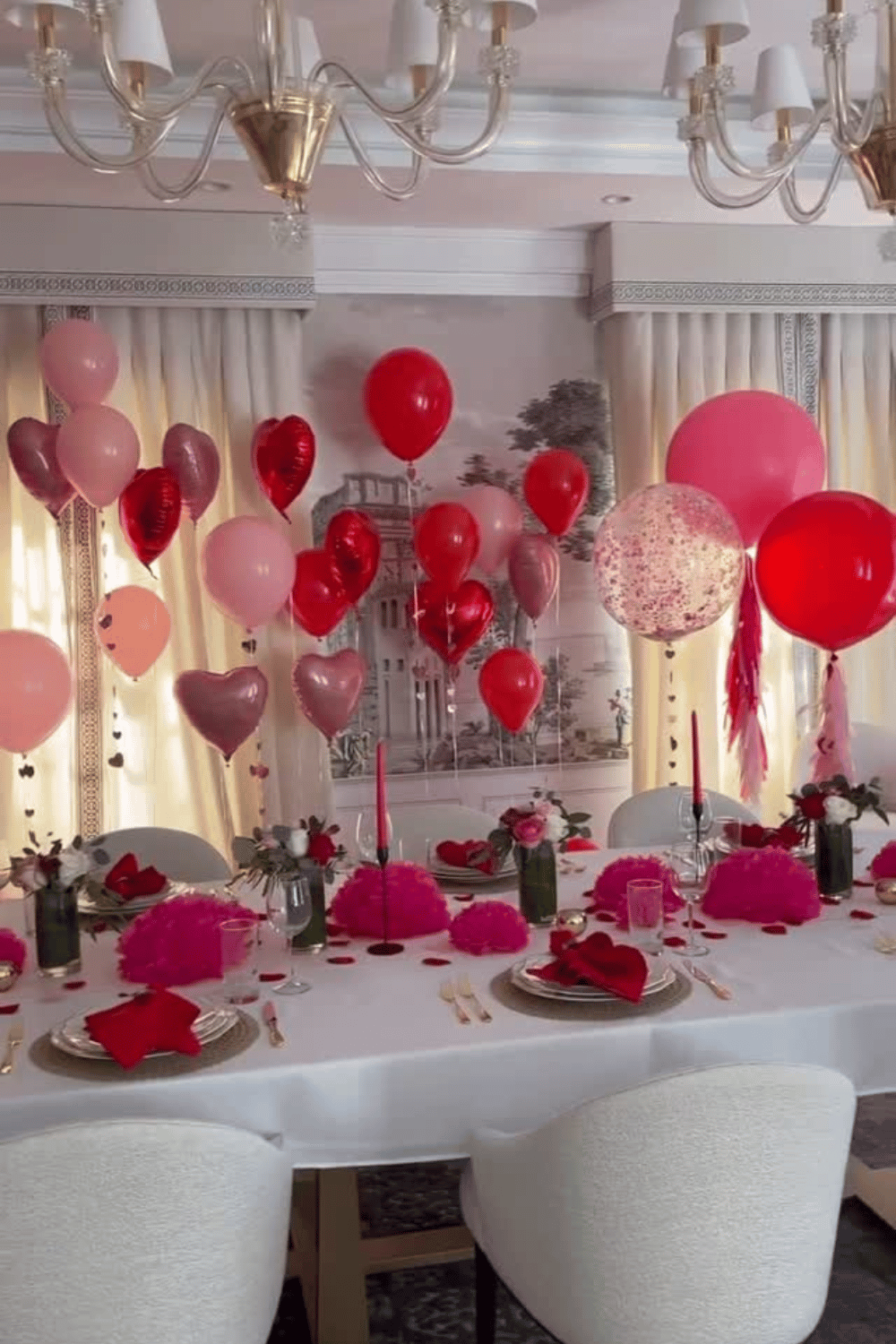 Galentine’s day party table with pink balloons, heart decorations, and candlelit centerpieces